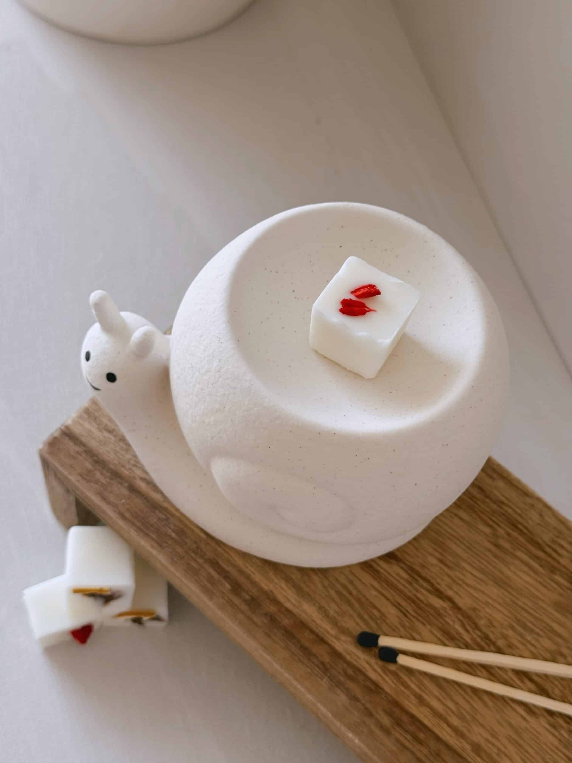 Quemador caracol de cerámica para wax melts visto desde arriba con cubito de cera en la bandeja.